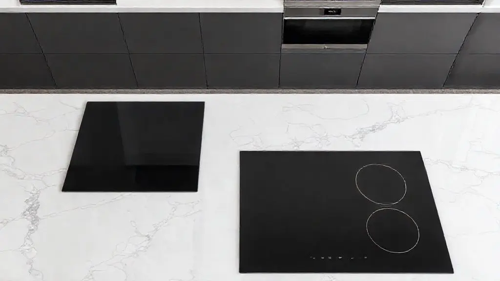 Fotografia comparativa de cooktop de indução moderno ao lado de um cooktop elétrico em bancada de mármore.