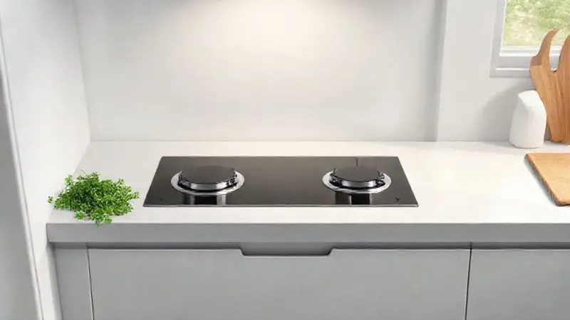 Ilustração de uma cozinha compacta moderna com um cooktop de 2 bocas embutido, focando na otimização de espaço.