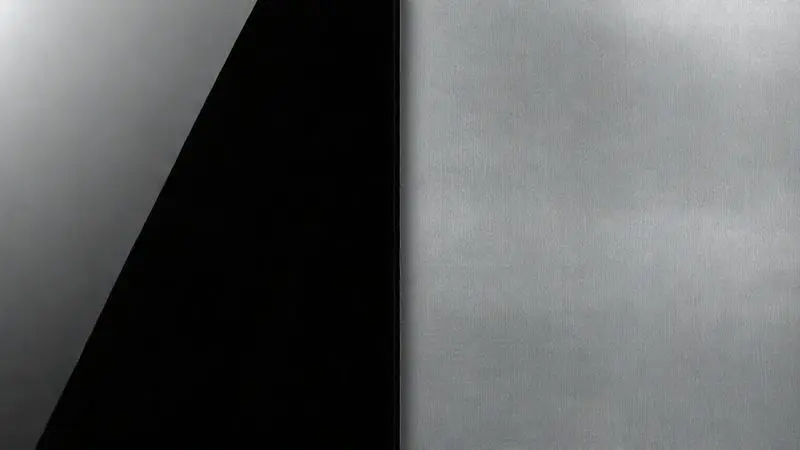 Texturas lado a lado de vidro preto elegante e aço inoxidável escovado durável, representando materiais de fogão.
