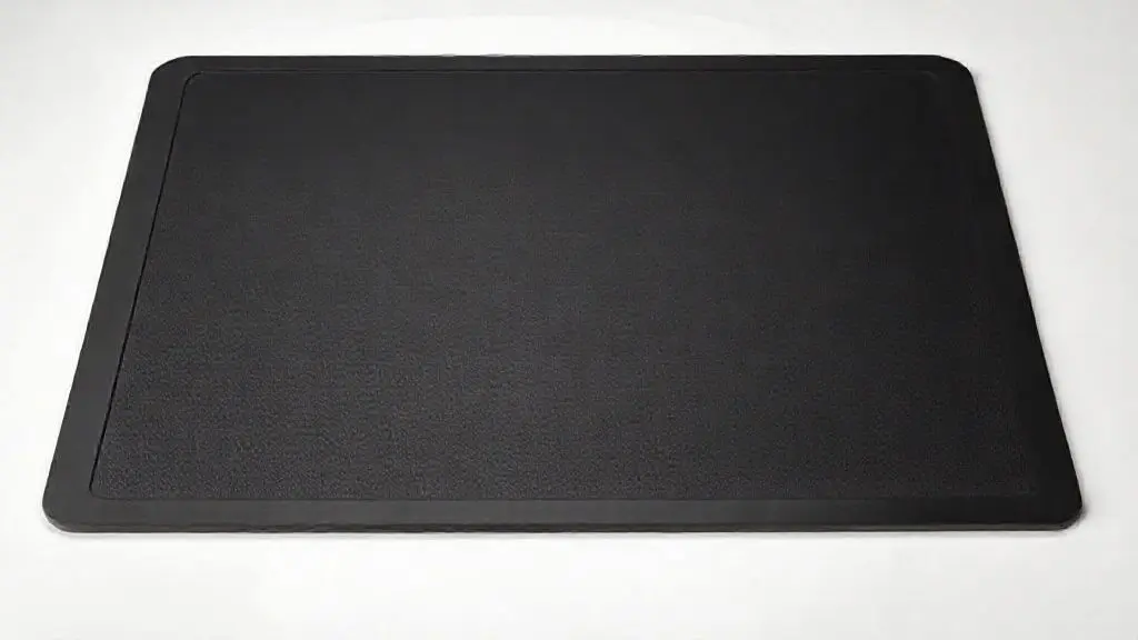 Fotografia ultra-realista de um protetor de silicone preto para fogão de indução, destacando a textura e o design minimalista para proteger a superfície.